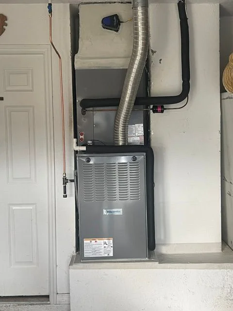 A technician testing AC electrical components including a capacitor and contactor inside an outdoor condenser unit at a residential property in Lakeland, Florida. The image shows hands-on electrical diagnostic work on a running air conditioning system in a Florida backyard setting.